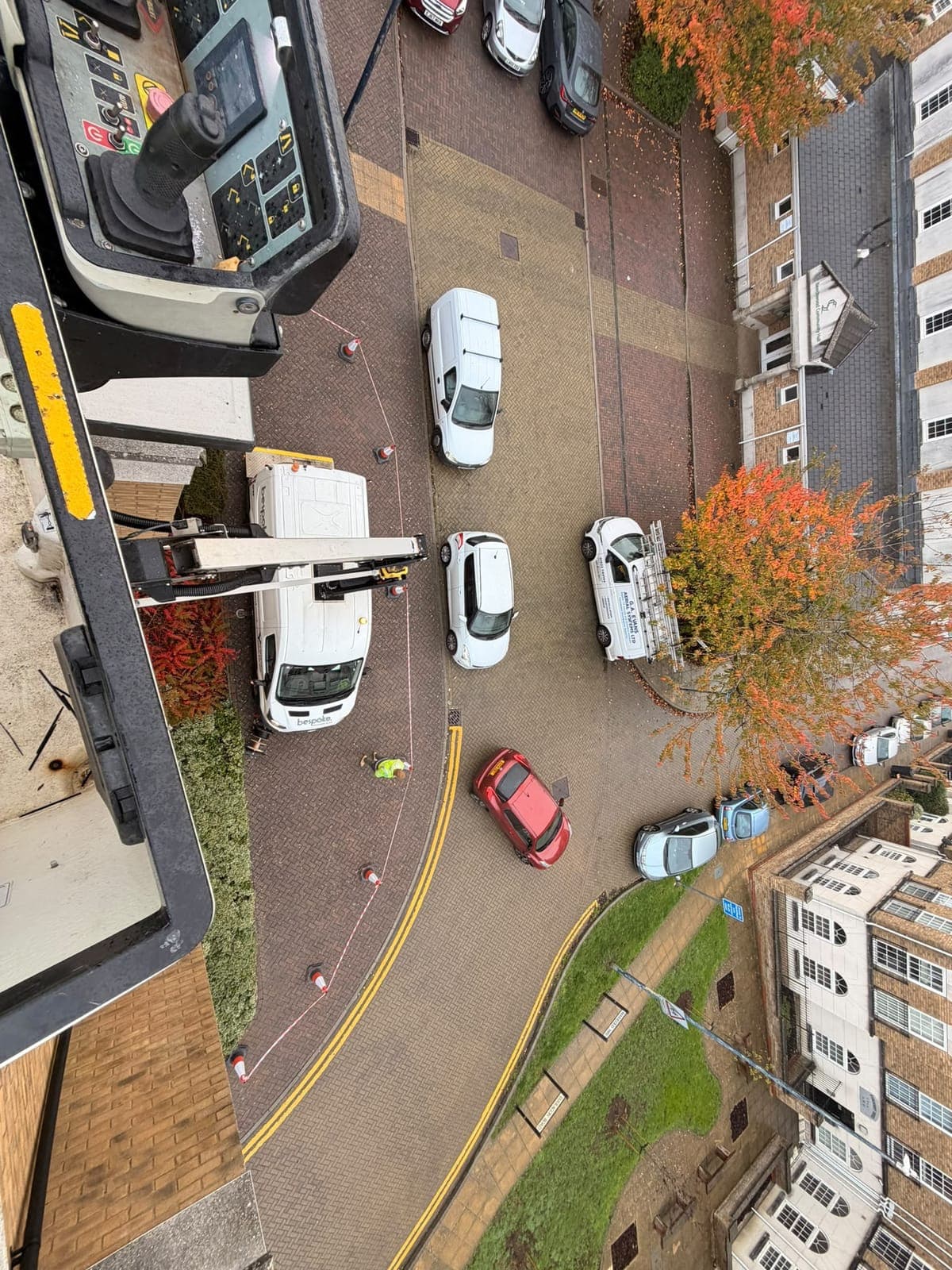 Looking down from the raised basket at the Bespoke Access Hire van and its coned off work area on the street below