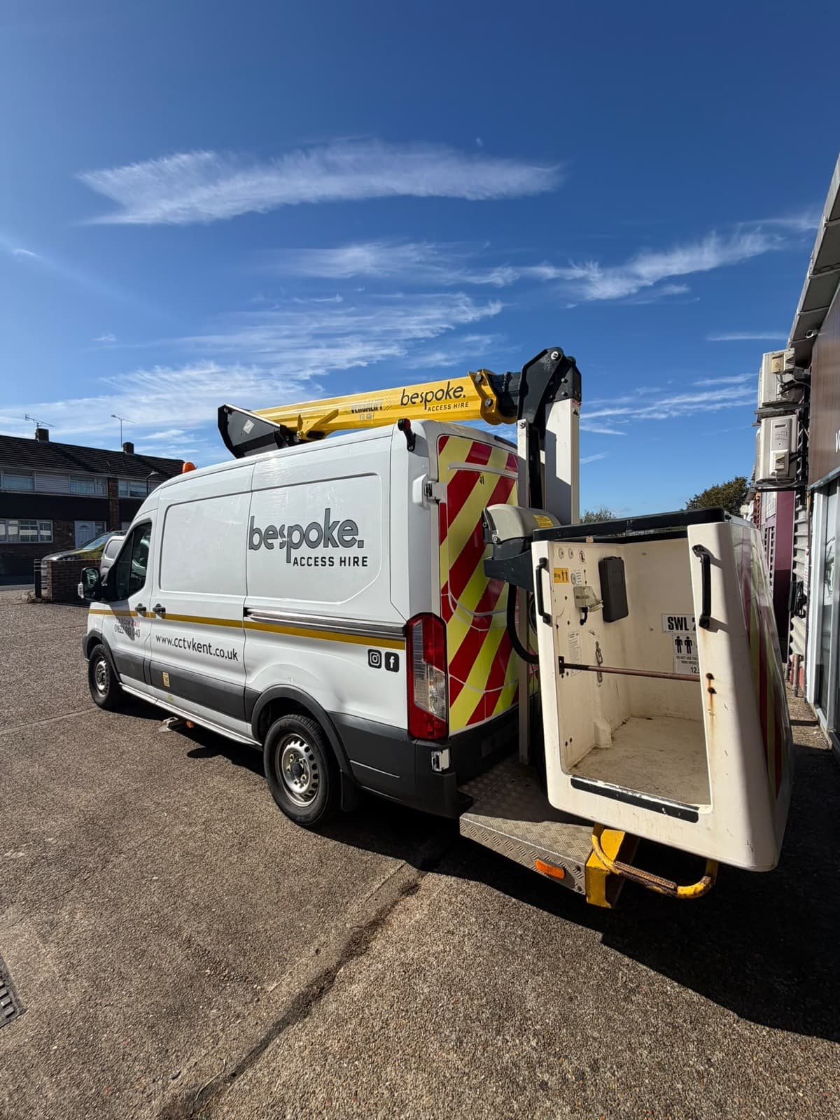 The cherry picker's platform basket open behind the Bespoke Access Hire van, with the Versalift boom stowed on the roof