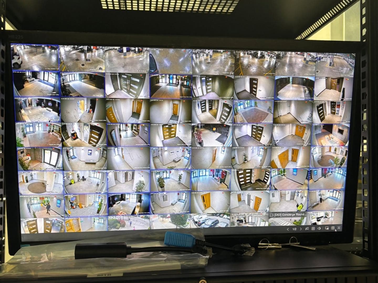 CCTV monitor showing dozens of live camera views across an apartment development's lobbies and car parks