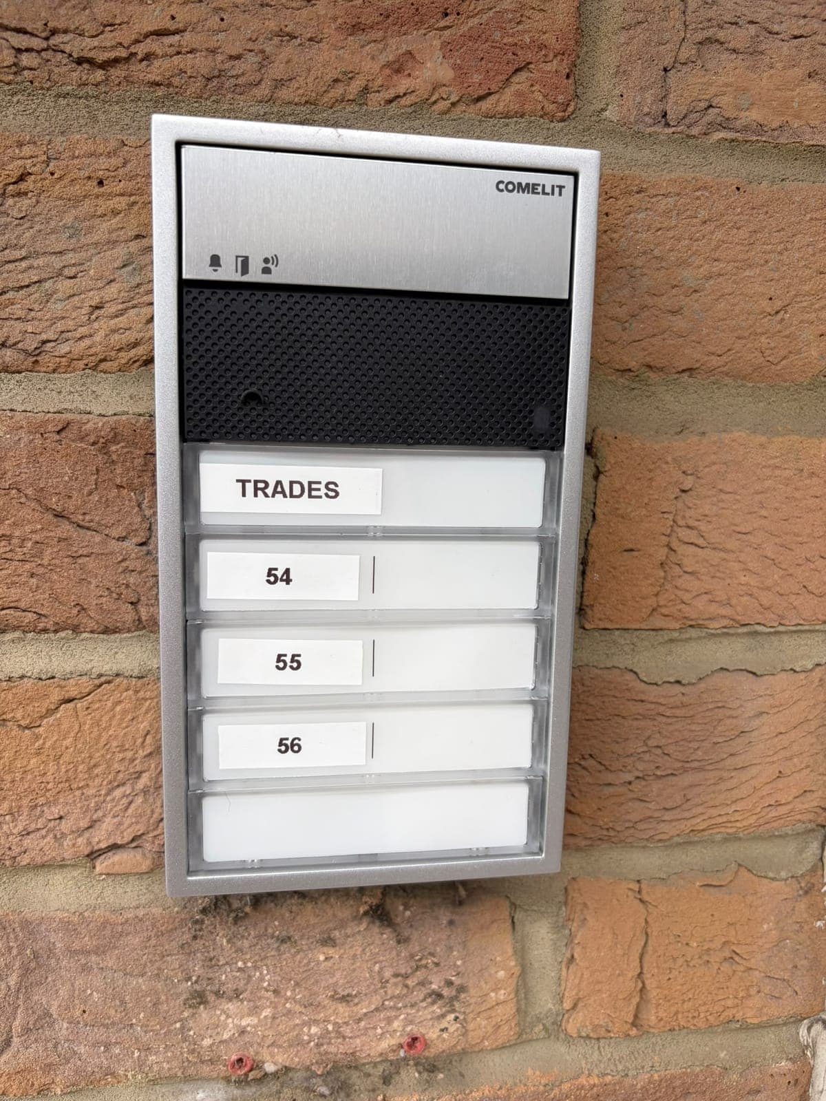 Comelit door entry panel on a block of flats, with a call button for each flat and a trades button