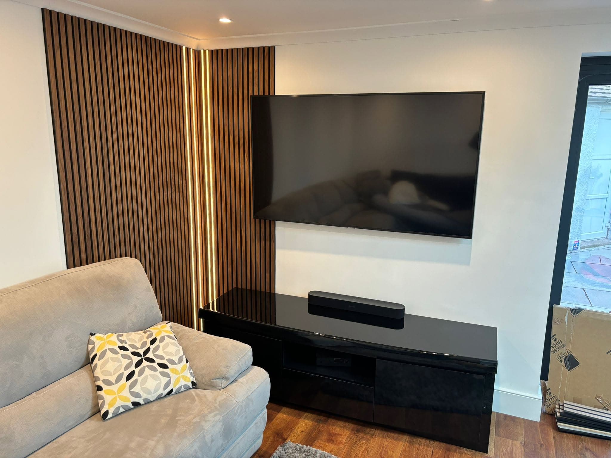 Slatted-oak media wall with LED lighting, wall-mounted TV and soundbar