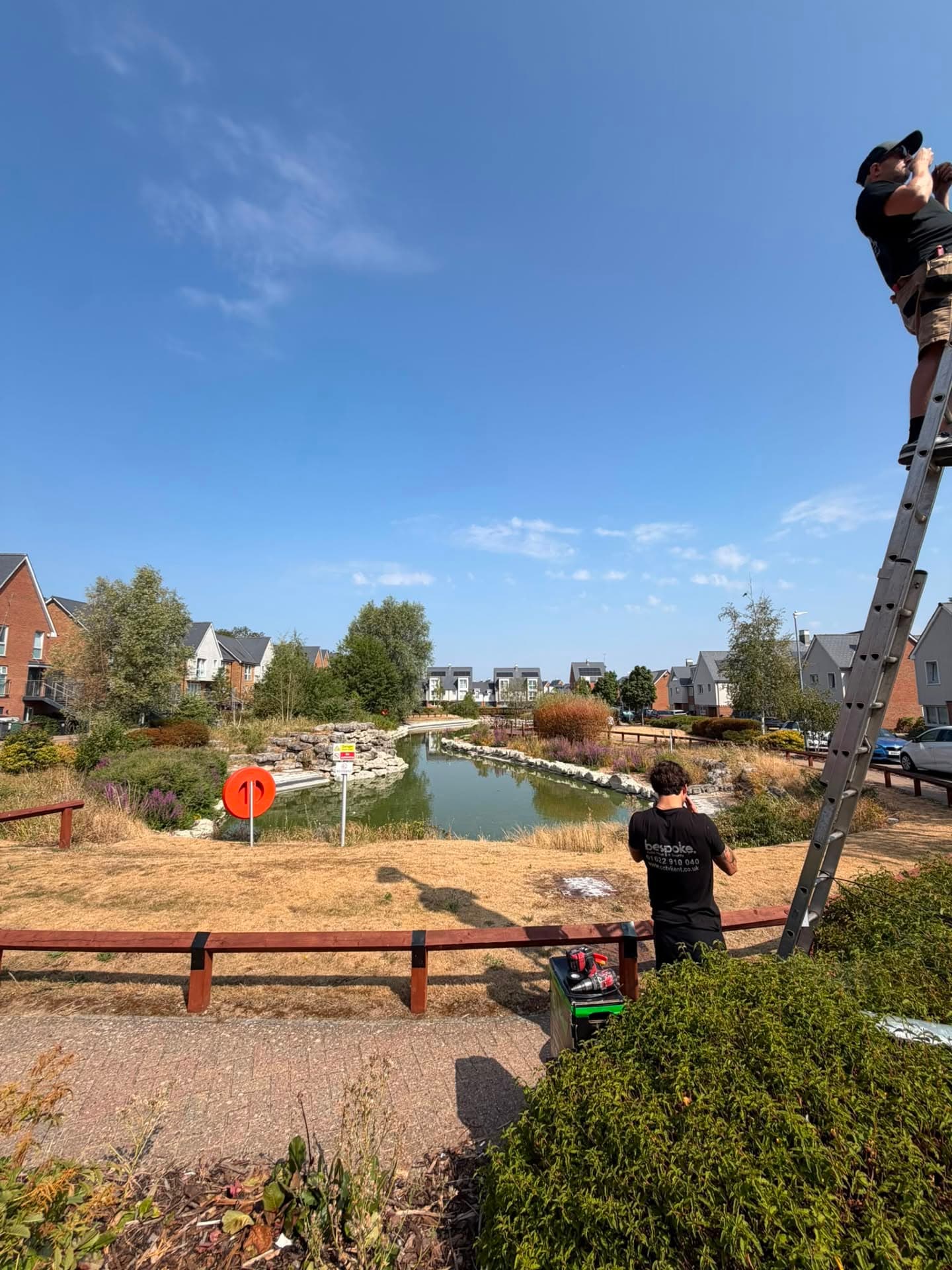 Bespoke AVS engineers working at height from a ladder at a residential development